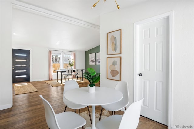 dining space featuring lofted ceiling and dark wood-type flooring