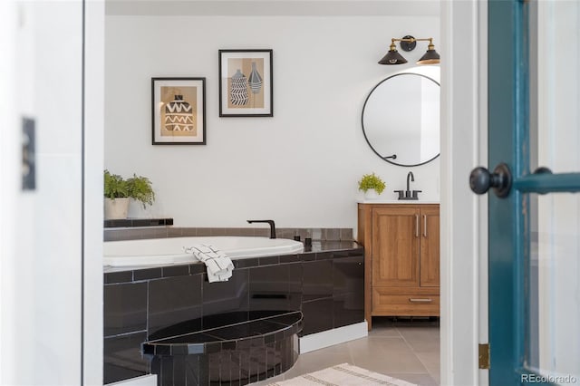 bathroom featuring tile patterned flooring, vanity, and tiled bath