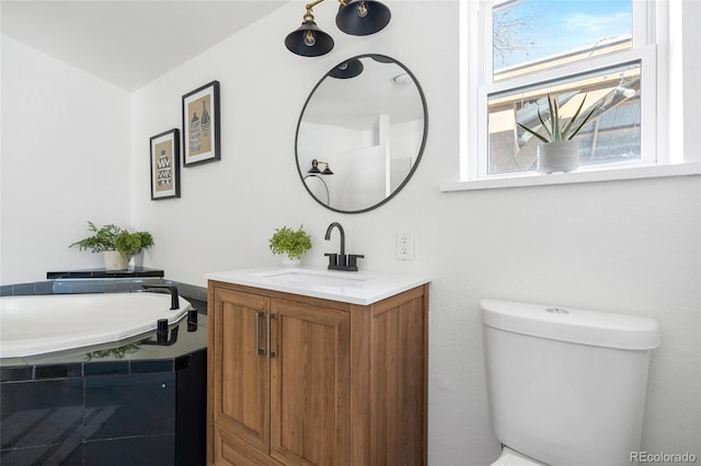 bathroom with vanity, toilet, and a bathtub