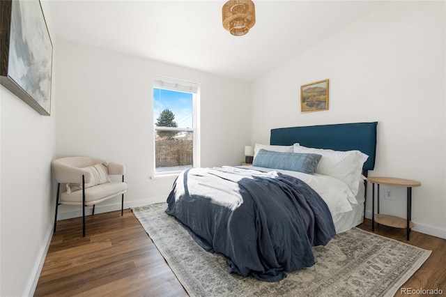 bedroom with vaulted ceiling and dark hardwood / wood-style floors