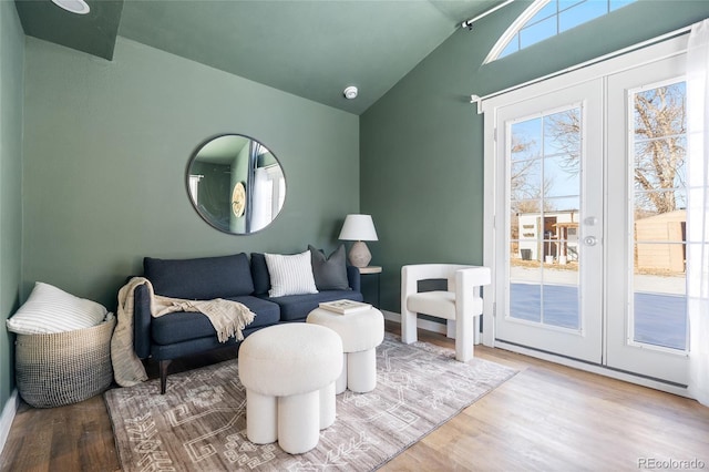 living room featuring lofted ceiling, wood-type flooring, and french doors