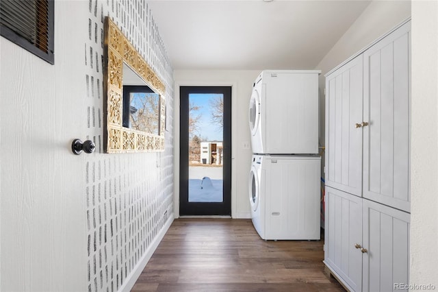 doorway featuring stacked washing maching and dryer and dark hardwood / wood-style flooring