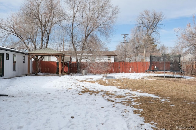 snowy yard with a gazebo and a trampoline