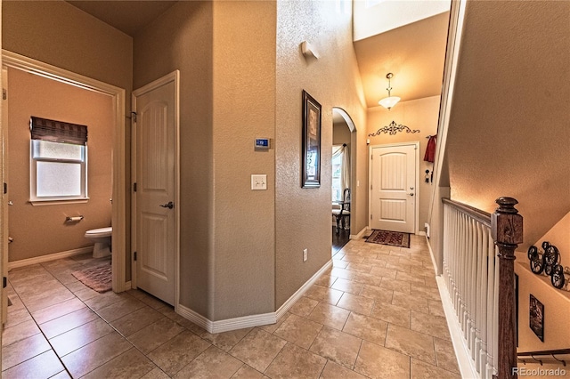 12420 Mount Belford Way, Peyton, CO 80831 - entrance foyer featuring a textured wall, plenty of natural light, arched walkways, and baseboards