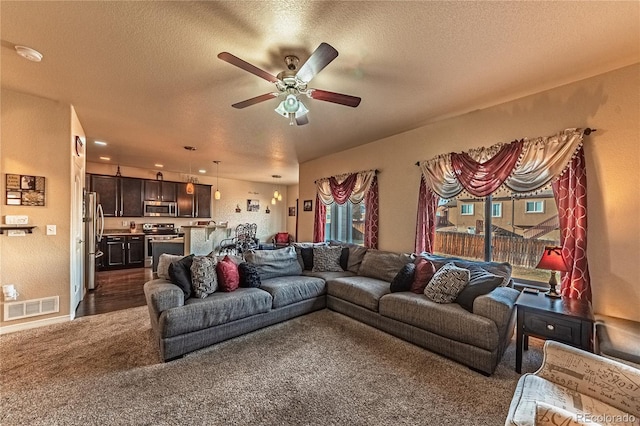 12420 Mount Belford Way, Peyton, CO 80831 - living area with dark carpet, ceiling fan, and a textured ceiling