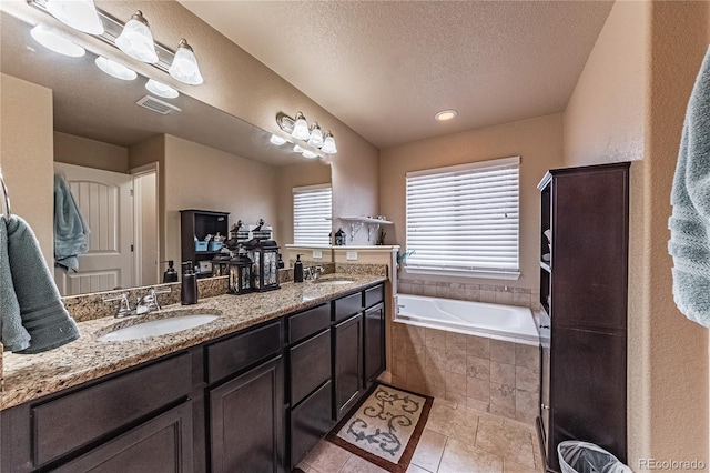 12420 Mount Belford Way, Peyton, CO 80831 - bathroom featuring double vanity, a bath, and a textured ceiling