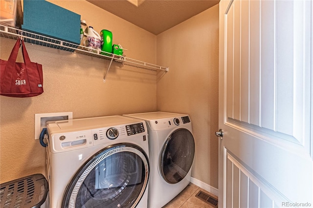 12420 Mount Belford Way, Peyton, CO 80831 - laundry room with washing machine and clothes dryer, light tile patterned flooring, and baseboards