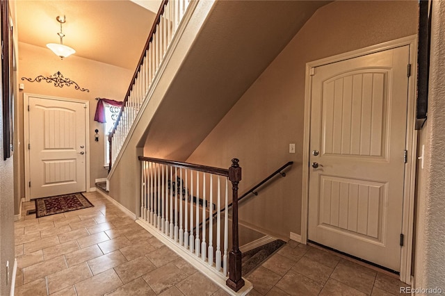 12420 Mount Belford Way, Peyton, CO 80831 - foyer entrance featuring lofted ceiling, baseboards, tile patterned flooring, and stairway