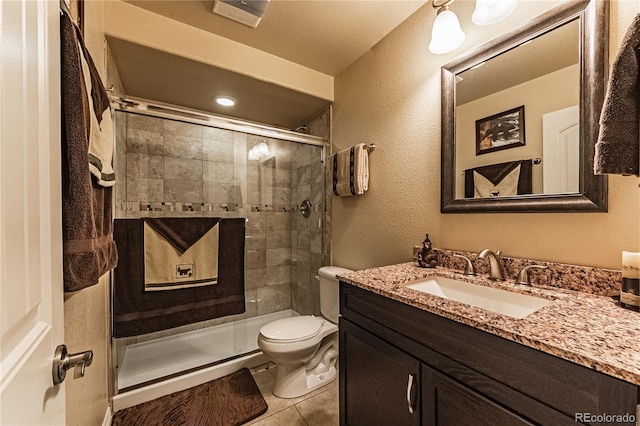 12420 Mount Belford Way, Peyton, CO 80831 - full bathroom with vanity, toilet, a stall shower, a textured wall, and tile patterned flooring
