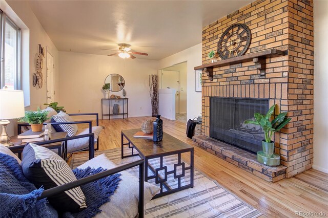 1227 Holmes Dr, Colorado Springs, CO 80909 - living room with a ceiling fan, light wood-type flooring, a fireplace, and baseboards