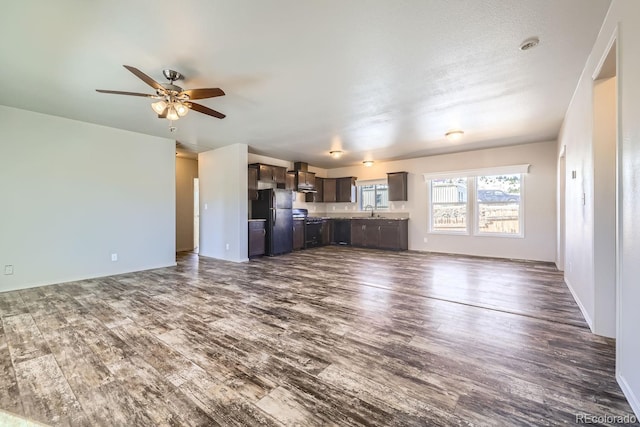 unfurnished living room with dark hardwood / wood-style flooring, ceiling fan, and sink