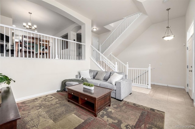 living room with stairs, a chandelier, a high ceiling, and carpet floors