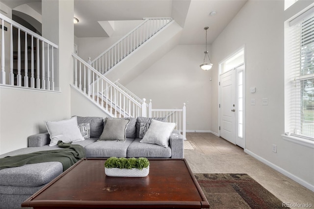 carpeted living room featuring stairway and baseboards