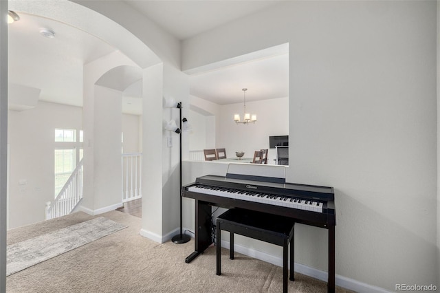 sitting room featuring arched walkways, a notable chandelier, carpet, and baseboards