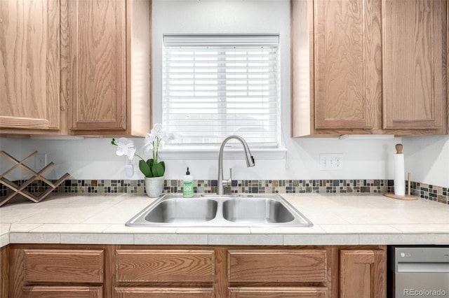 kitchen with dishwasher, light countertops, and a sink