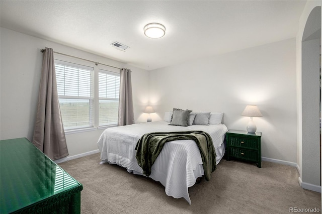 bedroom featuring visible vents, baseboards, and light carpet