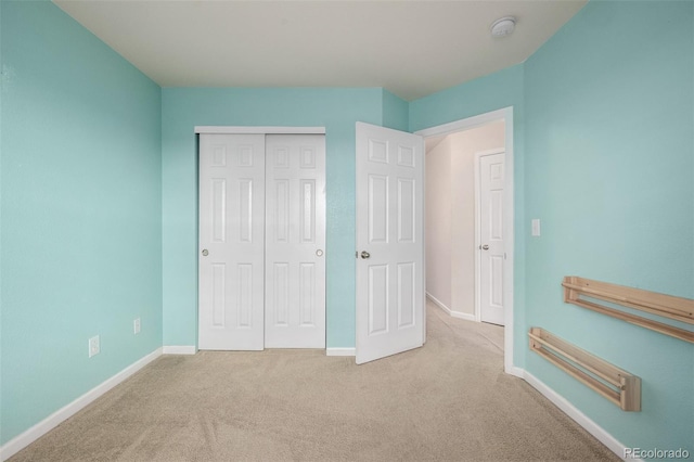unfurnished bedroom with a closet, baseboards, and carpet floors