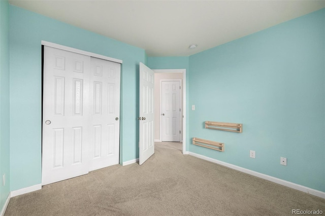 unfurnished bedroom with carpet floors, baseboards, and a closet