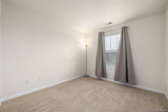 empty room featuring carpet floors, baseboards, and visible vents