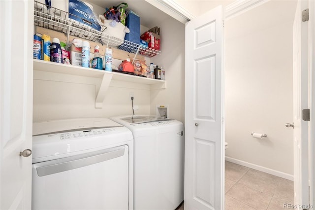 laundry room with washer and clothes dryer, laundry area, light tile patterned flooring, wet bar, and baseboards