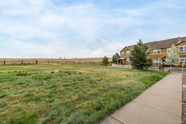 view of yard with a rural view and fence
