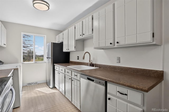 7902 Chase Cir Unit 152, Arvada, CO 80003 - kitchen with stainless steel appliances, dark countertops, and white cabinetry