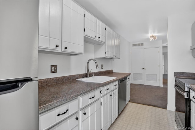 7902 Chase Cir Unit 152, Arvada, CO 80003 - kitchen featuring stainless steel appliances, dark countertops, white cabinets, light carpet, and light flooring