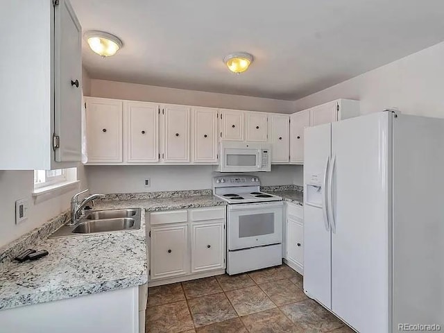 kitchen featuring white cabinetry, white appliances, and a sink