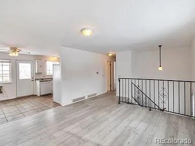 unfurnished room with ceiling fan, visible vents, and wood finished floors