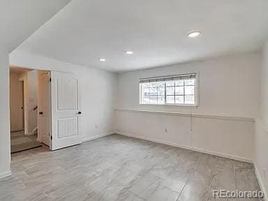 empty room featuring recessed lighting, baseboards, and wood finished floors