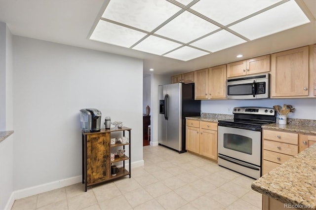kitchen featuring stainless steel appliances, light brown cabinetry, baseboards, recessed lighting, and light stone counters