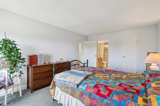 carpeted bedroom with a textured ceiling and ensuite bath