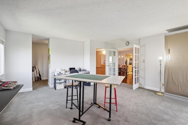 dining area with french doors, a desk, a textured ceiling, light carpet, and baseboards