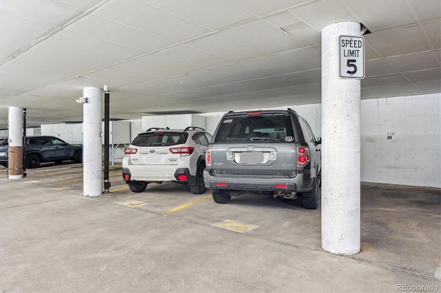 view of vehicle parking featuring a parking garage