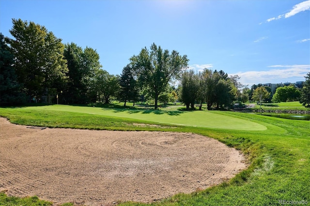 view of home's community featuring golf course view, a yard, view of wooded area, and a water view