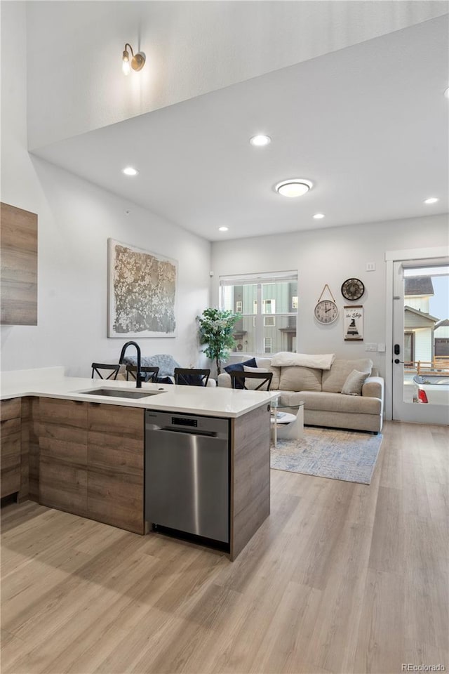 kitchen featuring sink, light hardwood / wood-style flooring, kitchen peninsula, and dishwasher