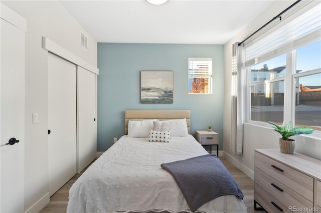 bedroom with light hardwood / wood-style floors and a closet