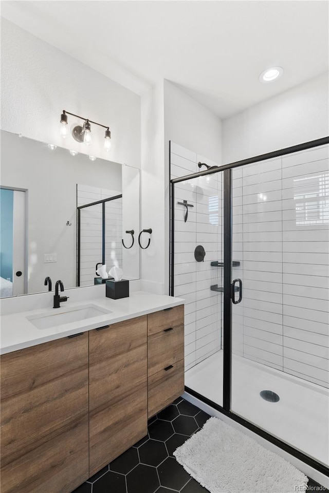 bathroom featuring vanity, a shower with door, and tile patterned floors