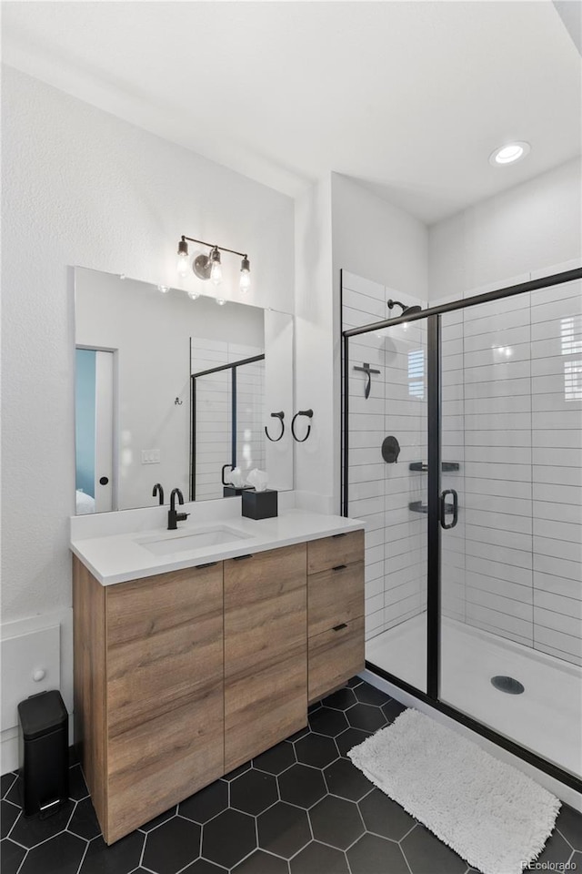 bathroom featuring a shower with door, vanity, and tile patterned flooring