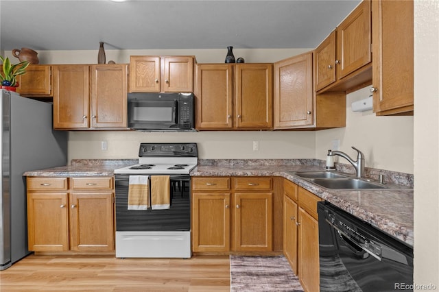 kitchen featuring black appliances, light hardwood / wood-style flooring, and sink