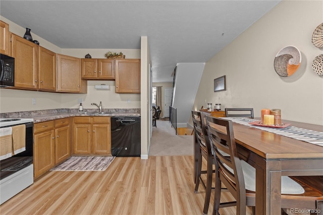 kitchen with light hardwood / wood-style floors, sink, and black appliances