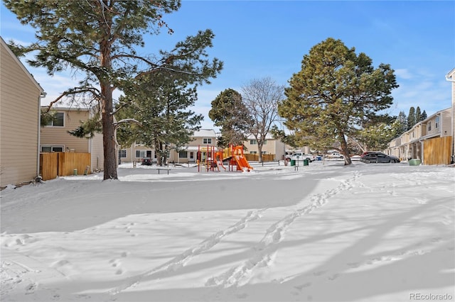 yard covered in snow featuring a playground