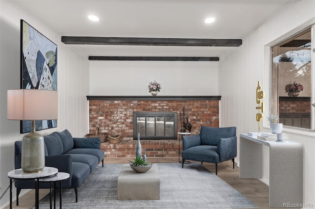 living area featuring a brick fireplace, wood finished floors, beam ceiling, and recessed lighting