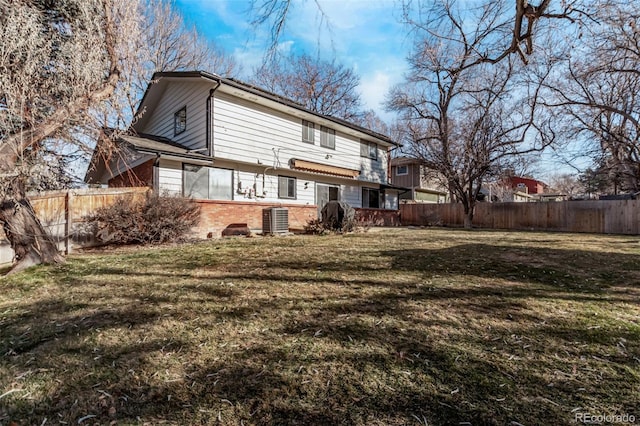 back of house featuring a lawn, fence, cooling unit, and brick siding