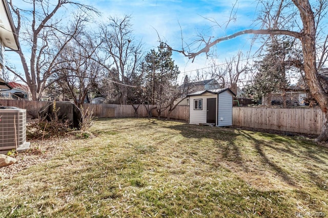 view of yard with an outbuilding, a storage shed, central AC unit, and a fenced backyard