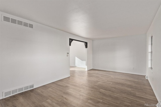 empty room featuring visible vents and wood finished floors