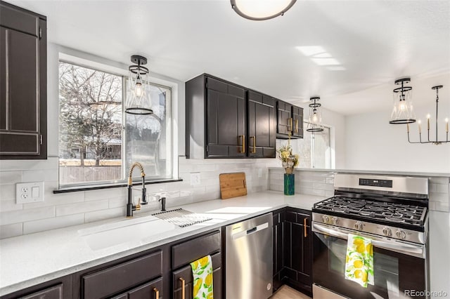 kitchen featuring decorative backsplash, appliances with stainless steel finishes, pendant lighting, and a wealth of natural light