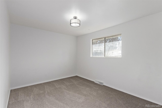 spare room with carpet, visible vents, and baseboards