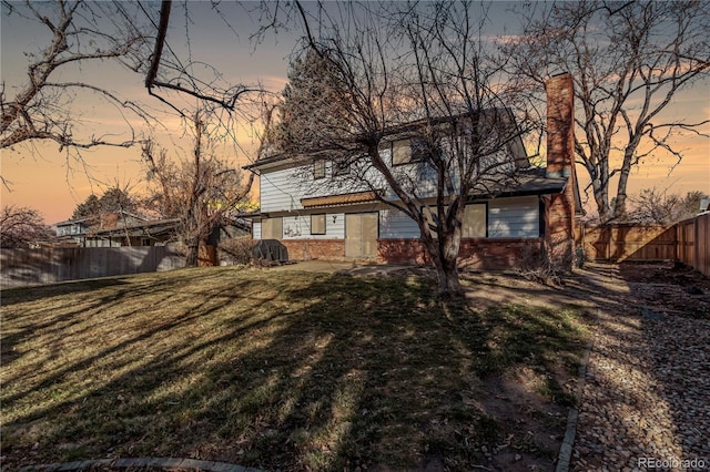 exterior space with brick siding, a lawn, and a fenced backyard