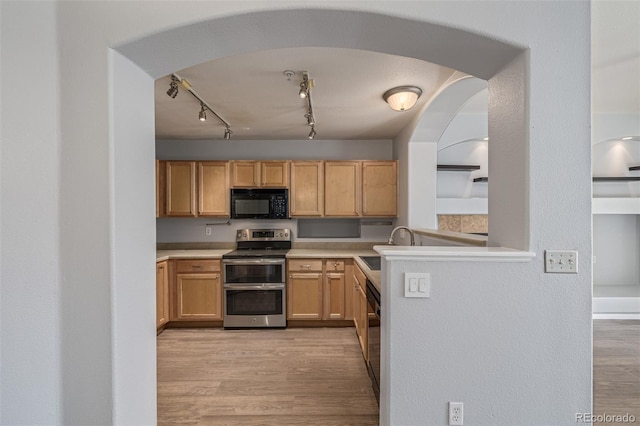 1535 S Florence Way Unit 410, Aurora, CO 80247 - kitchen with black appliances, light wood finished floors, light countertops, arched walkways, and track lighting